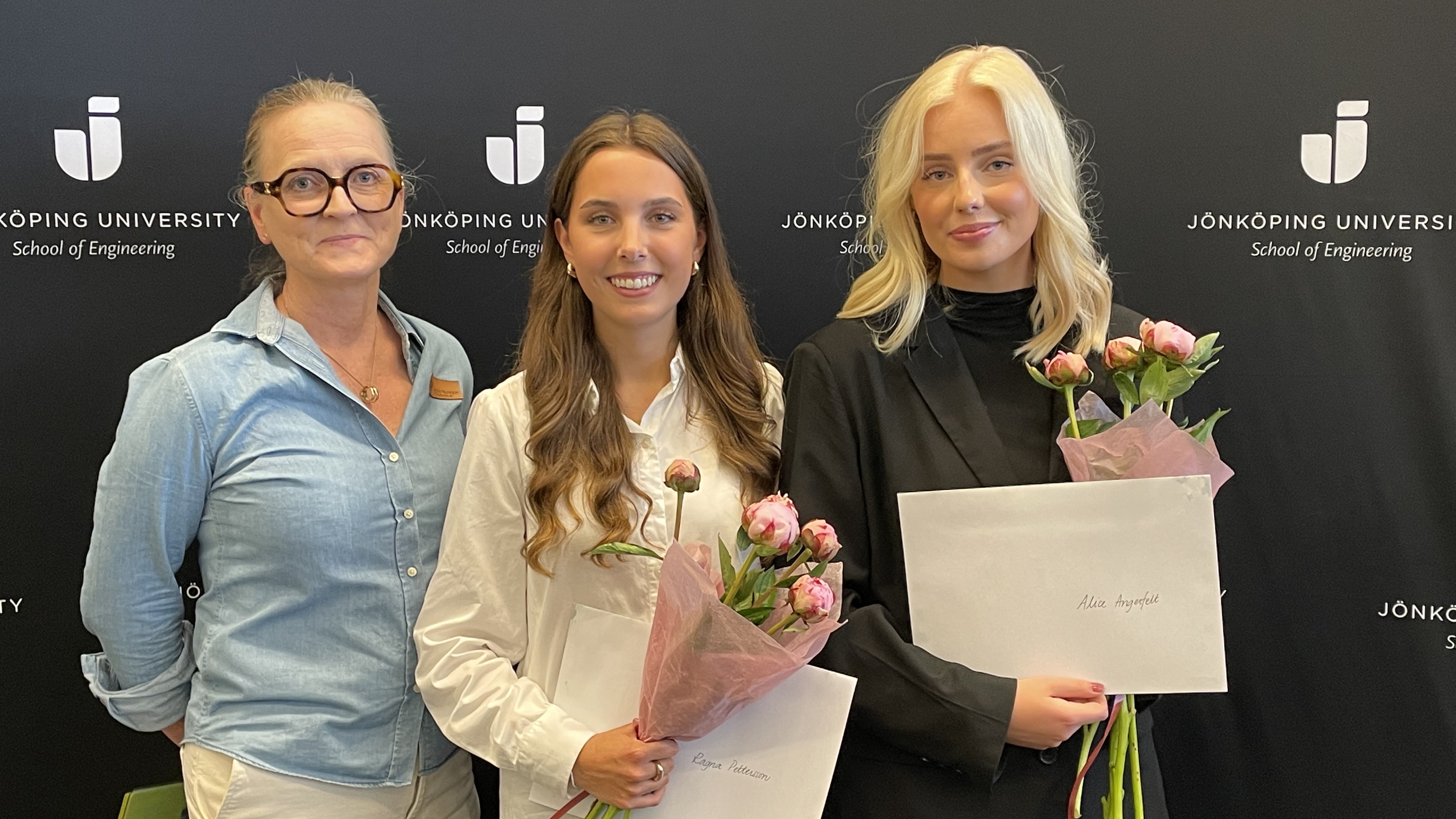 Bild på 3 kvinnor. Två av dem håller i blommor och diplom